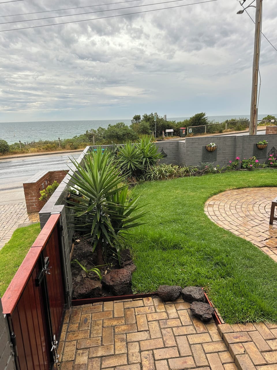 View from the front door - paving, grass and a view of the Bay.
