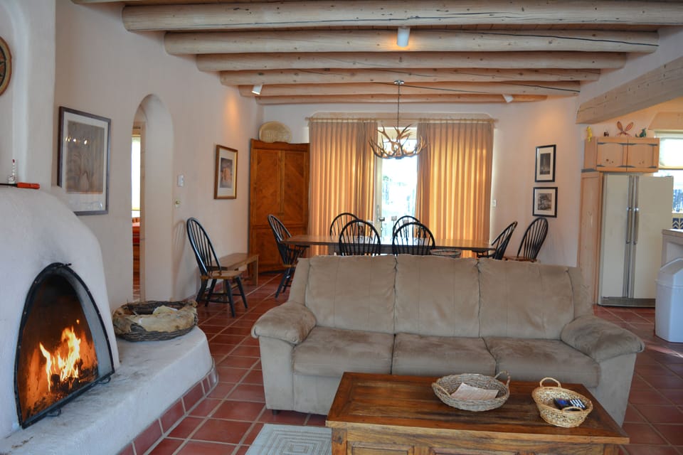 Fireplace views to dining table and entry hall on left to both guest bedrooms