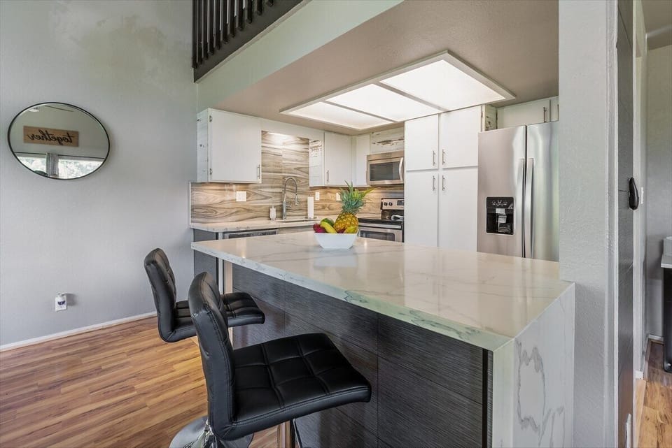 Newly remodeled kitchen with quartz countertops and a bar for two.