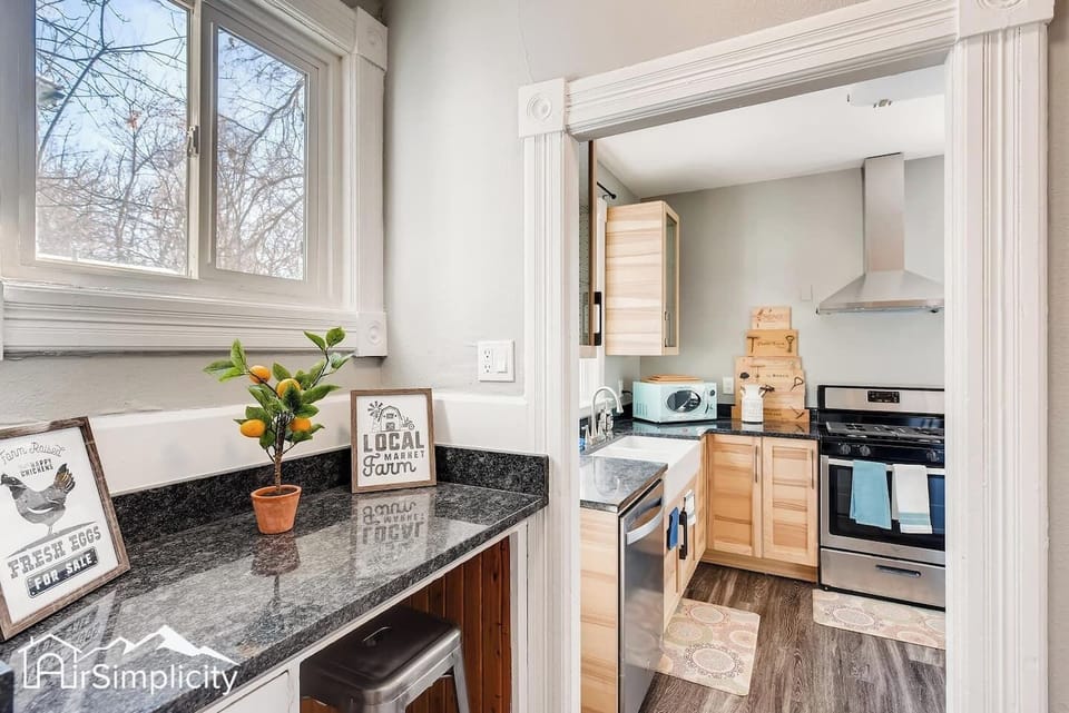 - Cozy breakfast nook features granite counter, bar stool seating, and sunny window views
- Cute farmhouse sign and small citrus plant add charm and personality
- Tucked just off the main kitchen area for a quiet morning coffee retreat

