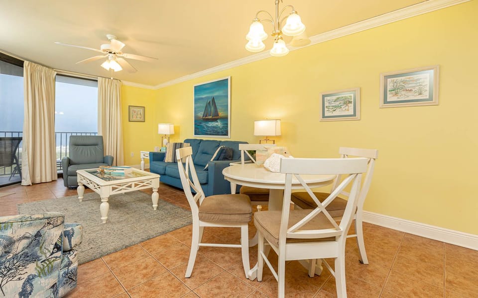 Cozy living area features a blue sofa with queen sleeper, dining table, and vibrant yellow walls, creating a cheerful vibe