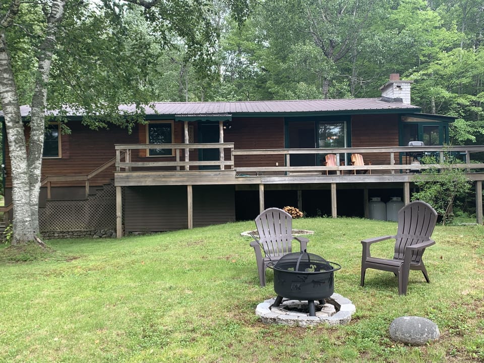 Front of house with fire pit and Adirondack chairs