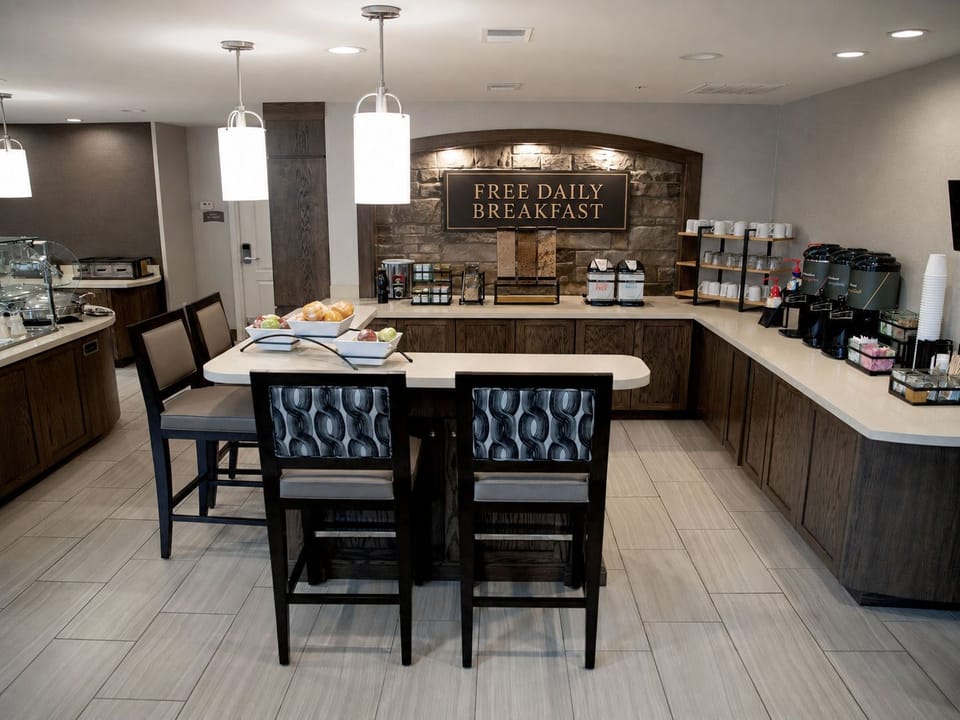 Breakfast bar with food display, beverage station, and free daily breakfast signage