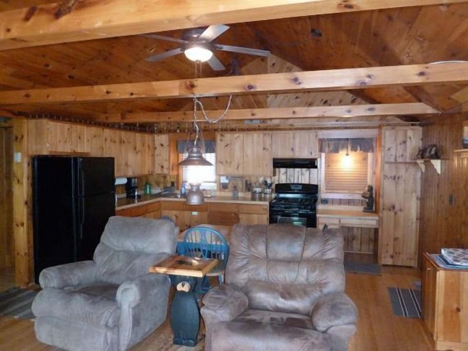 Knotty pine paneled open concept living & dining area.