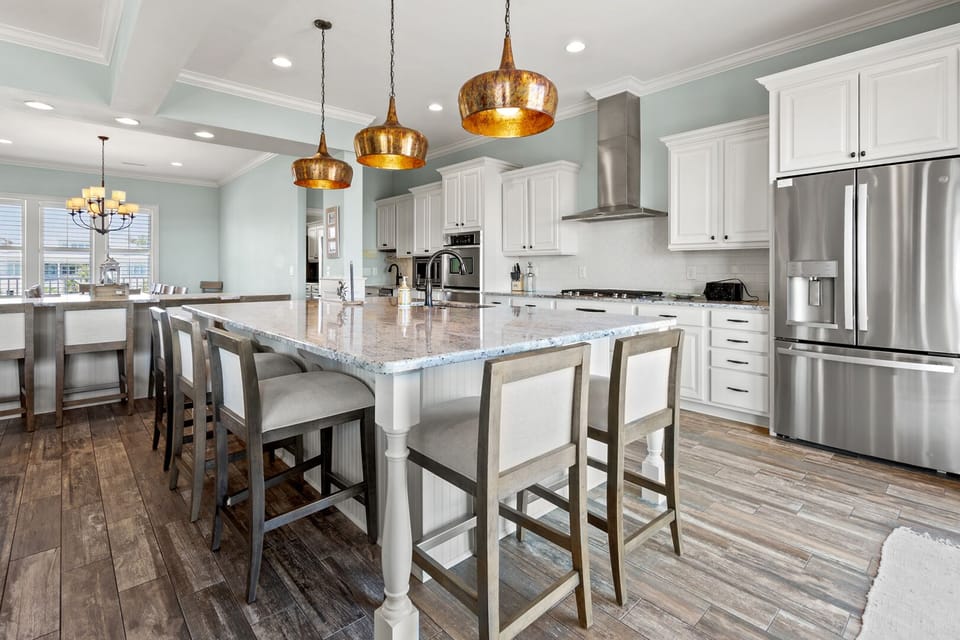White cabinetry, a gas cooktop and island seating in the kitchen at Beach House, Tilghman Beach