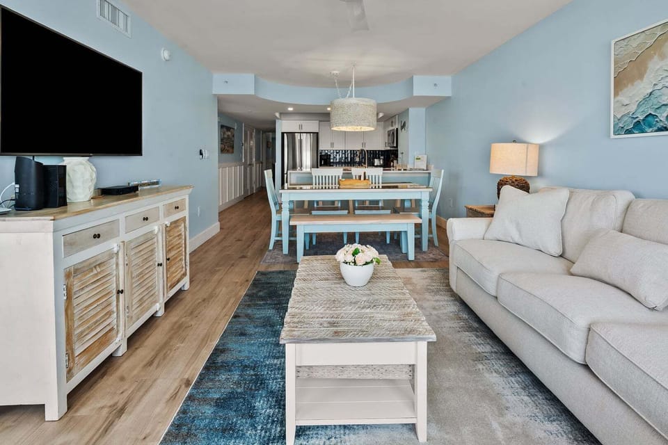 Open living and dining space with a wall-mounted TV at Beachwalk Villas 406, a 3-bedroom Cherry Grove condo rental