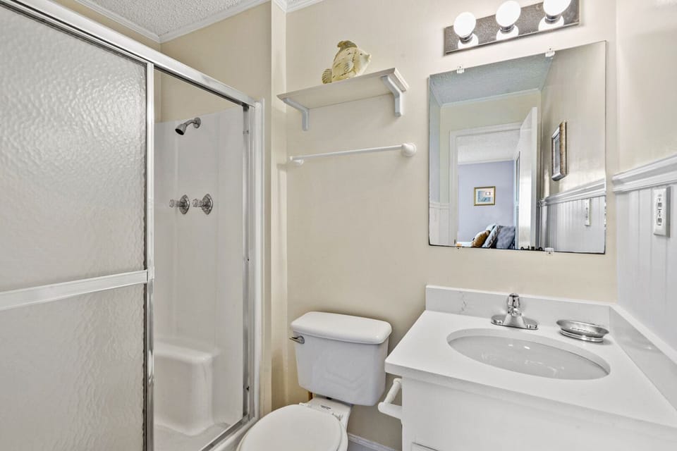 Bathroom with a sliding shower door and lighted mirror at Beachmaster 208 in Cherry Grove