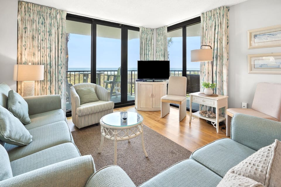 Sliding doors to the balcony beyond the sectional at Crescent Sands of Crescent Beach A1, a Crescent Beach condo