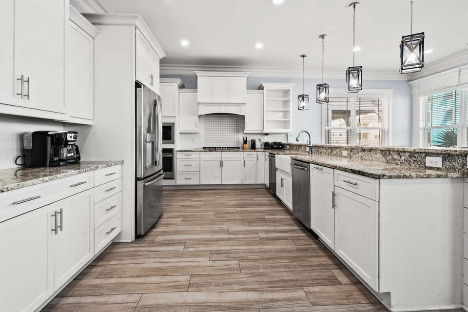 White cabinetry, under-cabinet lighting and an island sink at Ocean Current, a Cherry Grove vacation rental