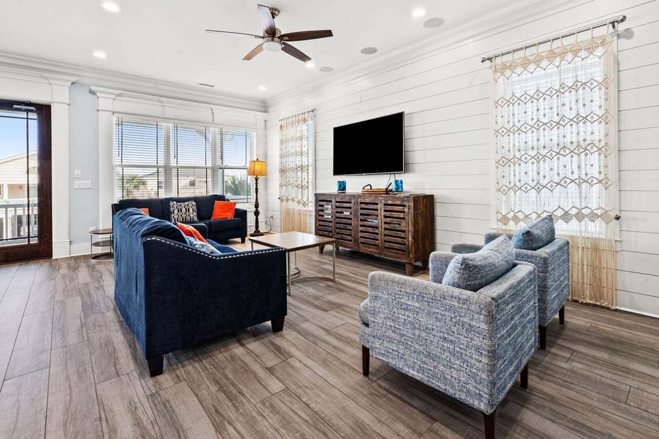 Blue sectional and a wide TV in the living room at Ocean Current, a 6-bedroom Cherry Grove rental