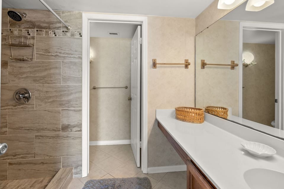 Walk-in shower and a vanity with two sinks in the bathroom at Shalimar 1B, a 2-bedroom condo in North Myrtle Beach