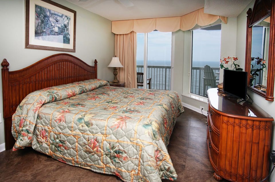 Bedroom with sliding doors to the ocean-view balcony at Paradise Pointe 10D, a 3-bedroom Cherry Grove condo rental