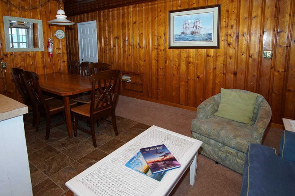 Dining table and armchair beside the living area at Sandy Shores 2, Cherry Grove, North Myrtle Beach