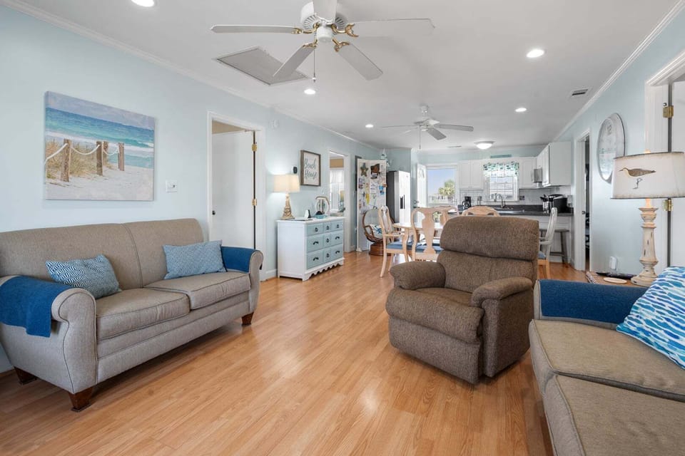 Open living and kitchen space with a ceiling fan and dining table at Anchor in the Waves, a Cherry Grove vacation rental