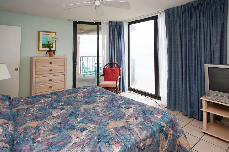 Bedroom with balcony doors and a TV at Sea Castle 6D in Crescent Beach, North Myrtle Beach