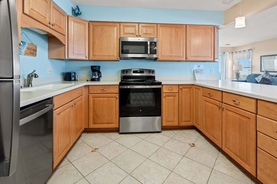 Full kitchen with a range, microwave and light counters at Sand Trap Villas C1, Cherry Grove, North Myrtle Beach