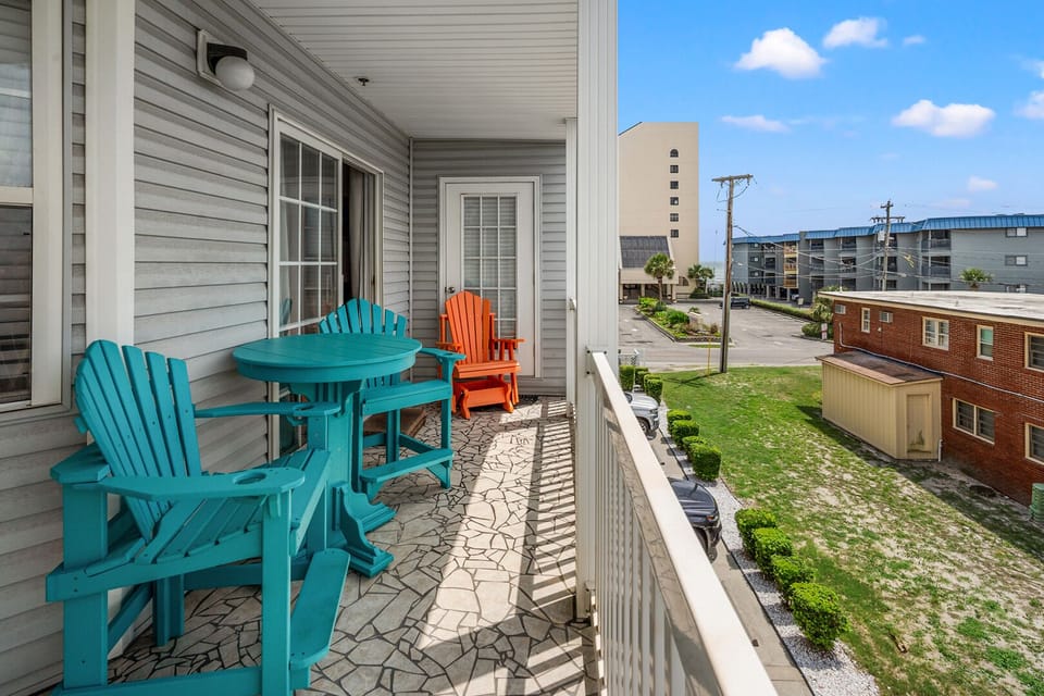 Teal and orange chairs on the porch at Ocean Pointe Villas 3B, a 4-bedroom Cherry Grove vacation rental