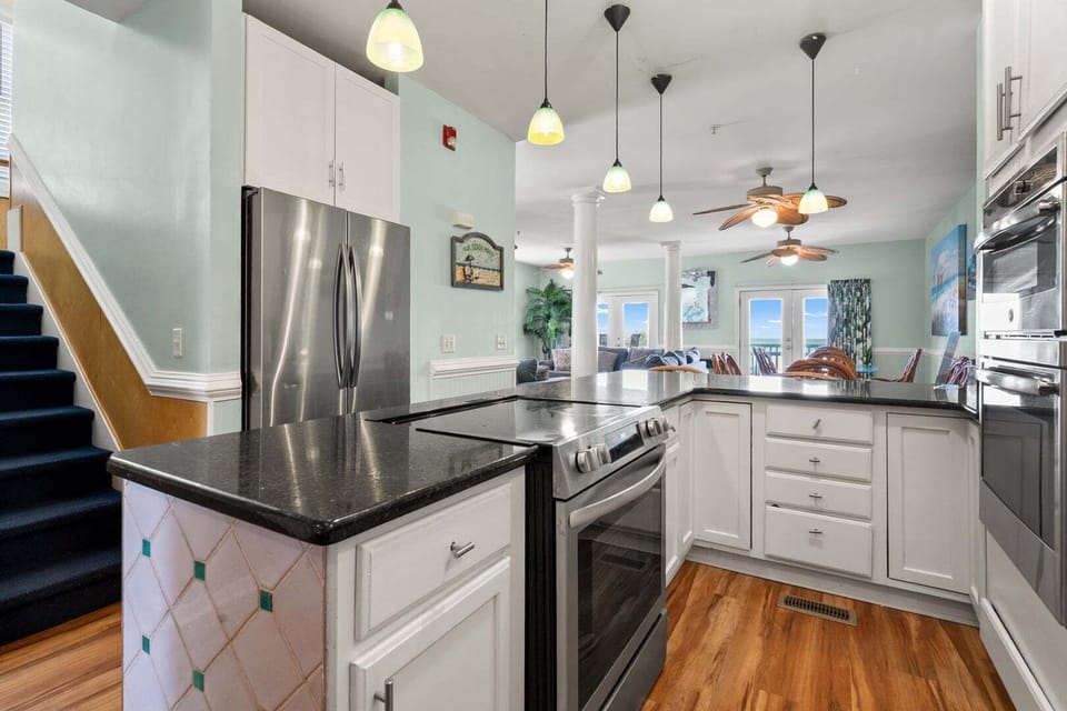 White cabinetry and a dark counter in the kitchen at Diamond Dunes A, an 8-bedroom Crescent Beach rental