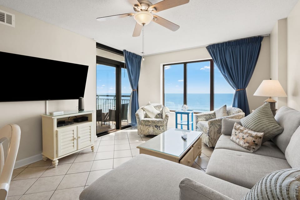 Sectional sofa and mounted TV facing the balcony doors at Beachwalk Villas 603, Cherry Grove vacation rental