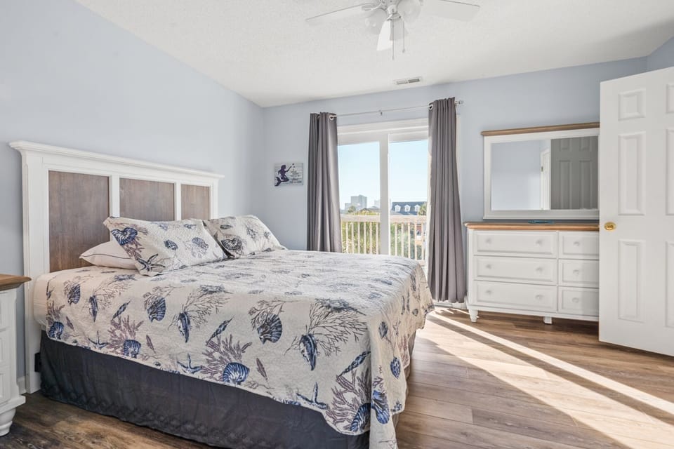 Bedroom with balcony doors and ocean views at Ship Happens, a 4-bedroom Cherry Grove rental in North Myrtle Beach
