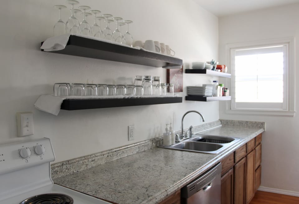 The kitchen is fully stocked with cooking and eating utensils.