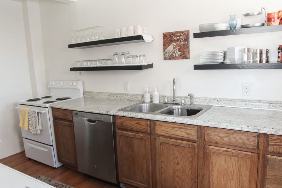 The kitchen is fully stocked with cooking and eating utensils.
