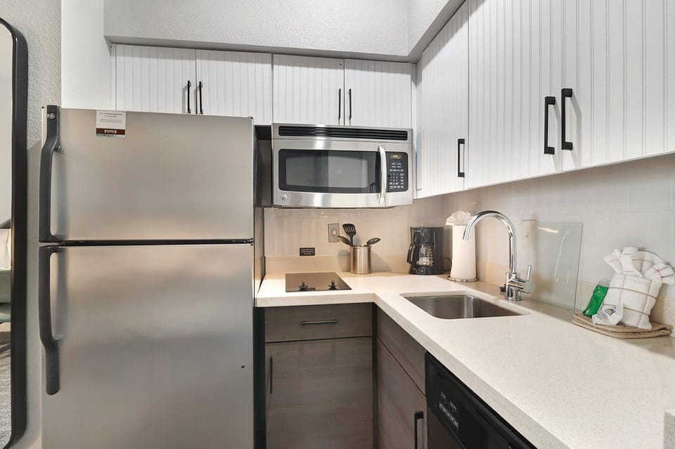 Gather around the sleek kitchenette, complete with stylish storage and cooking essentials for your culinary adventures.