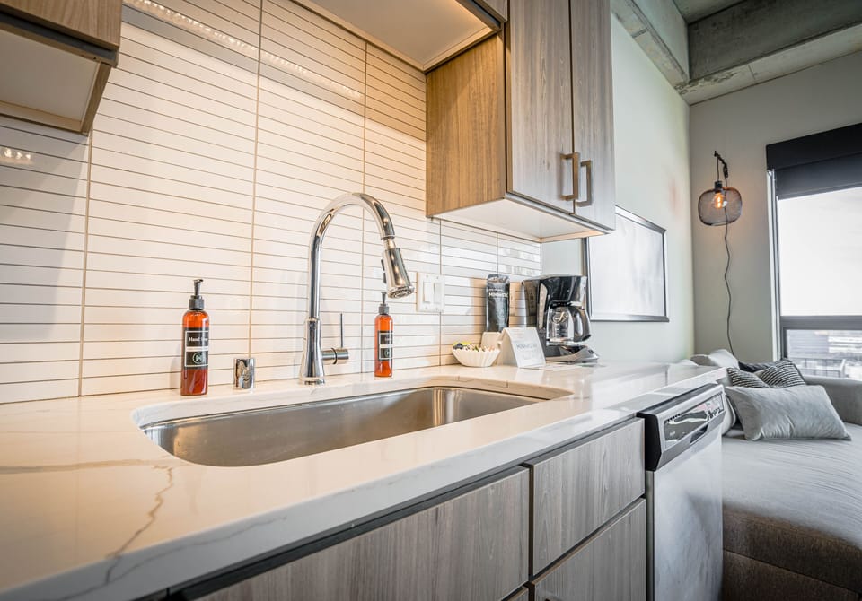 Your stylish kitchen awaits with modern appliances and marble countertops, perfect for preparing morning coffee while enjoying city views.
