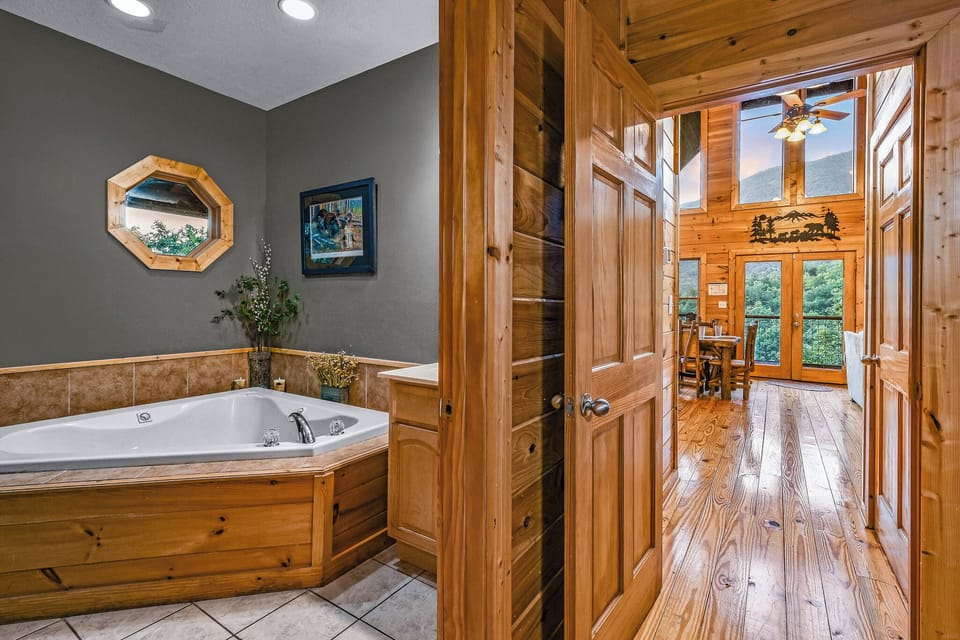 Luxurious master bathroom featuring a corner Jacuzzi tub and walk-in shower at Ali's Dream cabin in Wears Valley, Tennessee — just 15 minutes from Pigeon Forge.