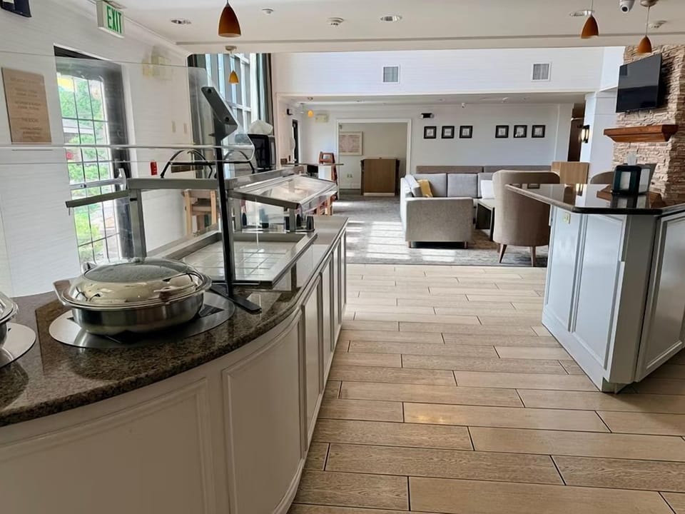 Enjoy complimentary breakfast in a welcoming dining area with natural light and cozy seating.