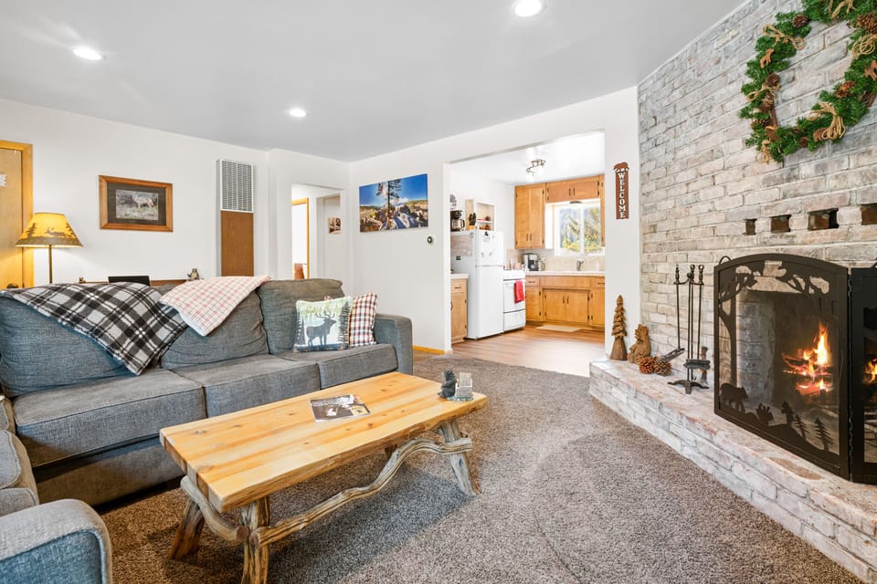 Living Room with wood burning fireplace, smart TV, large sectional couch.