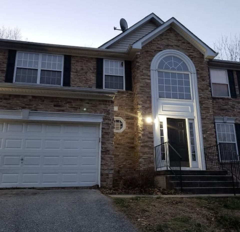 Parking on the left side of driveway in front of  white garage door