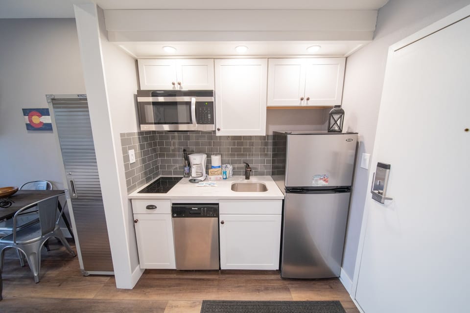 Kitchenette with stove top and refrigerator
