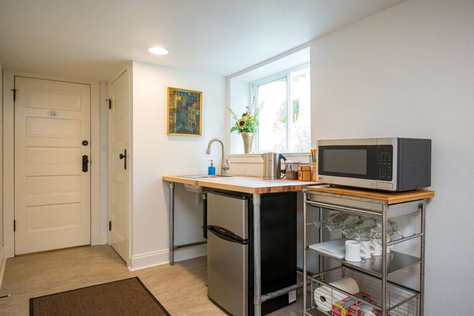 Kitchenette with refigerator/freezer, microwave, toaster, hot water kettle.