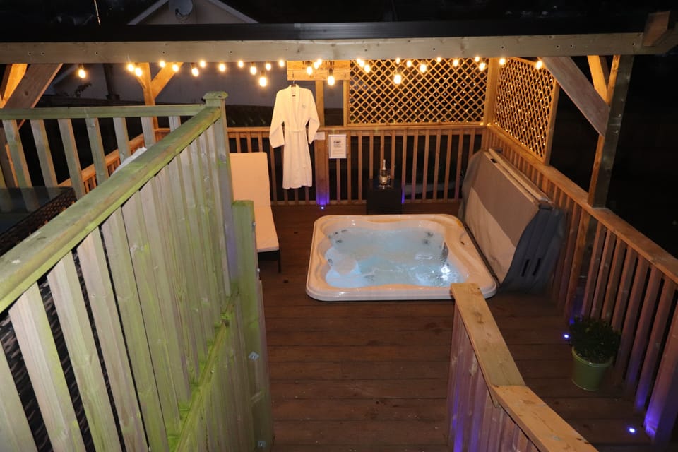 Steps lead from upper deck down to covered hot tub