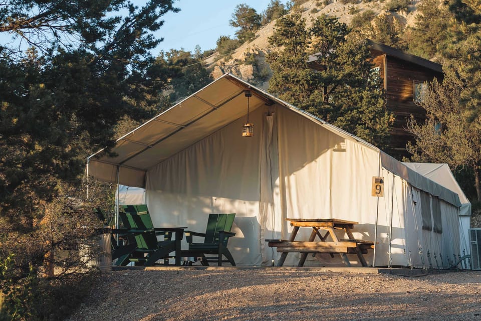 Spacious glamping tent with covered outdoor living space, cozy beds, dining area, and everything you need for a comfortable Southern Utah stay.