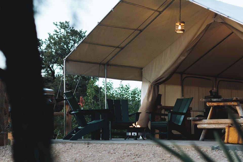 Spacious glamping tent with covered outdoor living space, cozy bed, dining area, and everything you need for a comfortable Southern Utah stay.