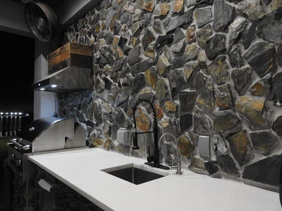 Chef`s kitchen featuring dramatic natural boulder stone accent wall, luxury Orlando vacation rental