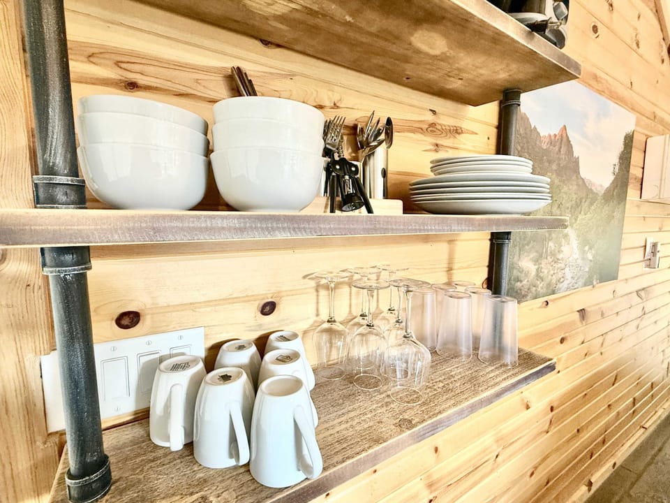 Well-stocked kitchen area with kitchenware, hot plate, utensils, cookware, and essentials for preparing simple meals during your glamping stay.