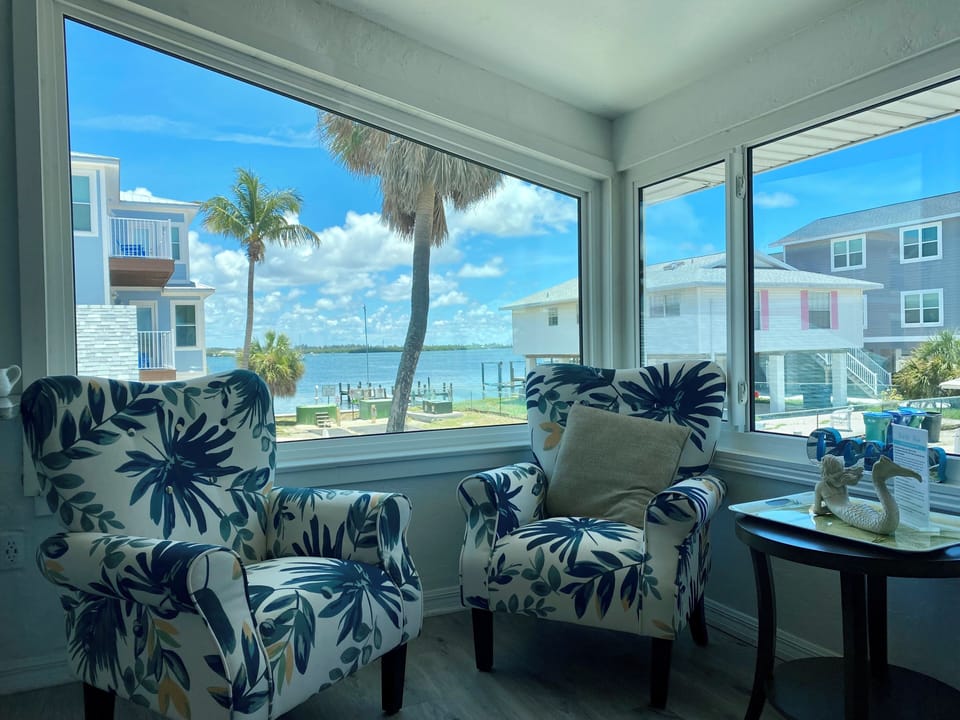 Views looking to Sarasota Bay + boats + night-time lights Dining + Sitting Room