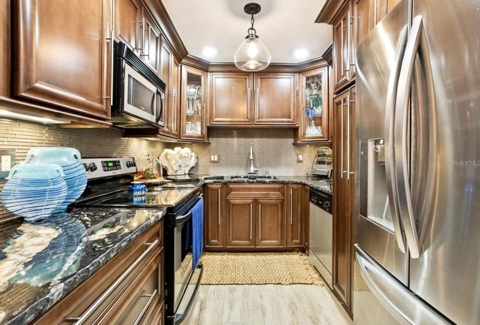 High end custom cabinetry with live edge granite.  A fully stocked kitchen. 