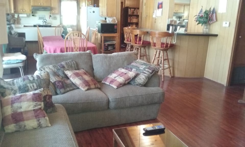 Living room from fireplace to kitchen, bar, dining area