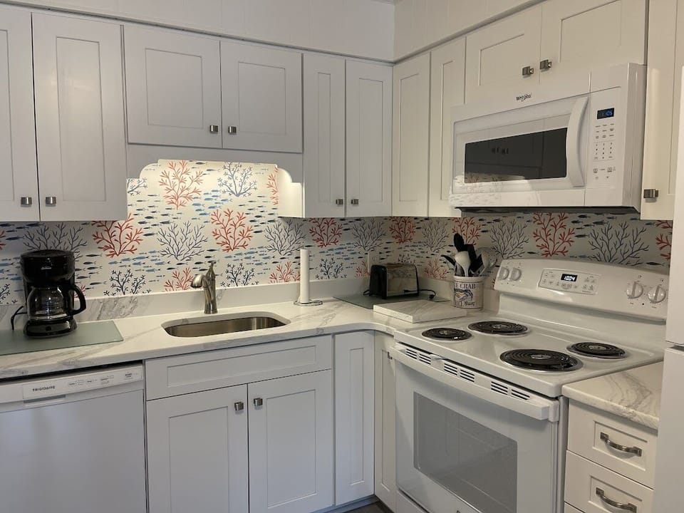 Coffee maker, toaster, cookware, and dishes are provided.