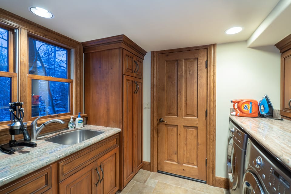 Laundry room with sink and stainless steel washer and dryer.