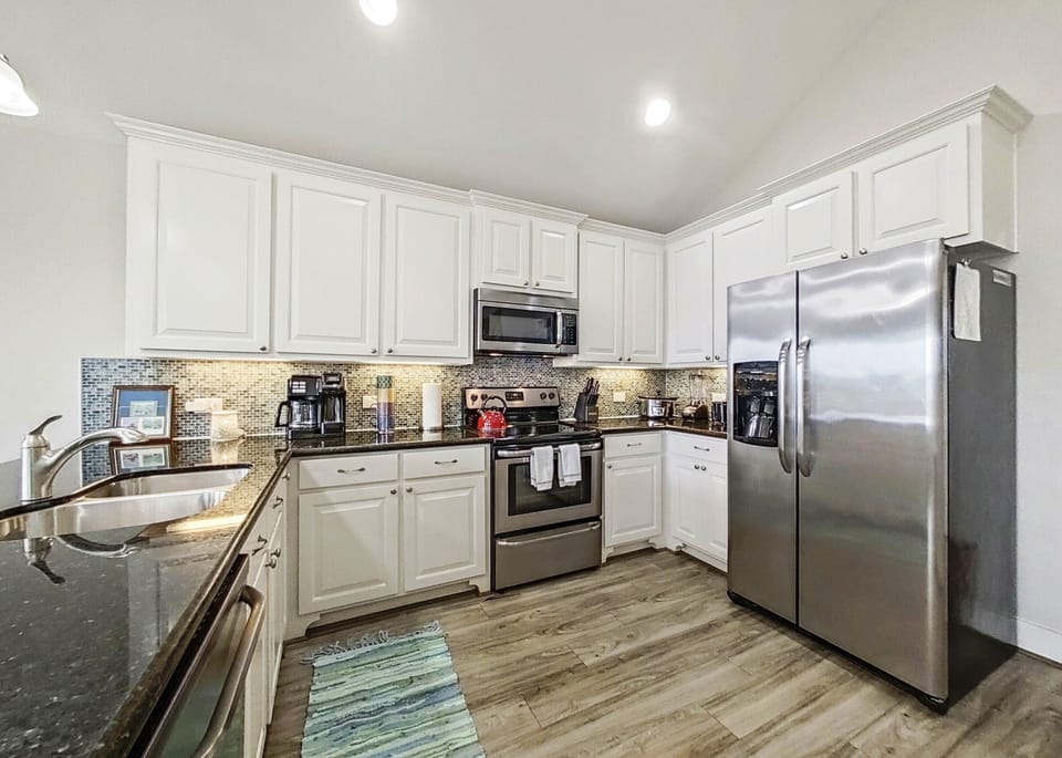 Full kitchen with stainless appliances & a complement of small appliances.
