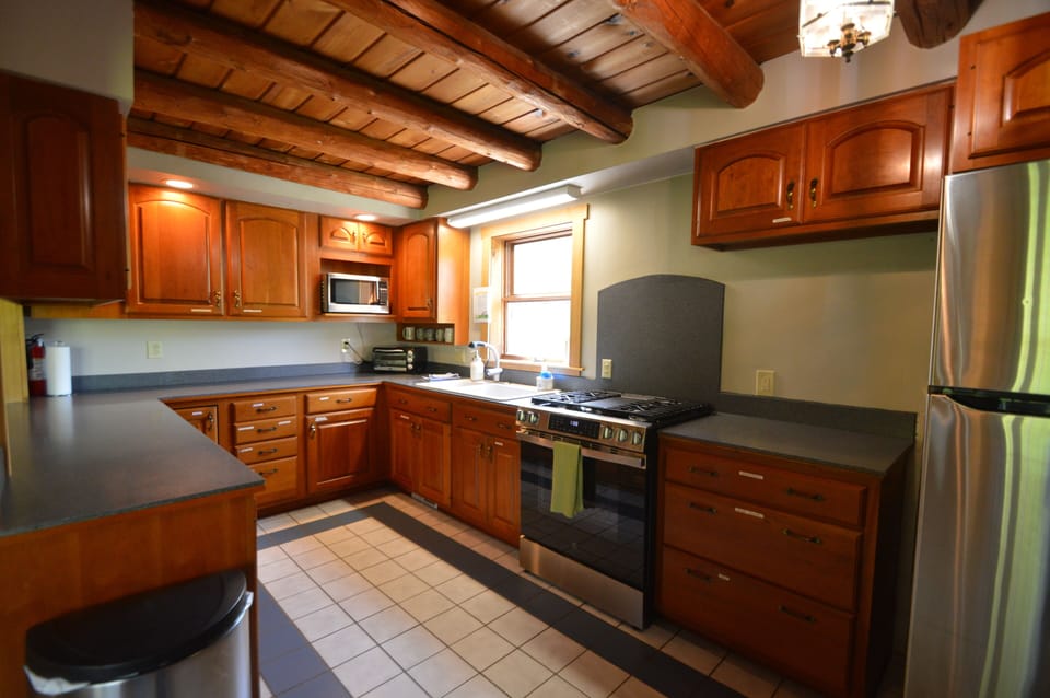 Well equipped kitchen with toaster oven, microwave, and refrigerator.