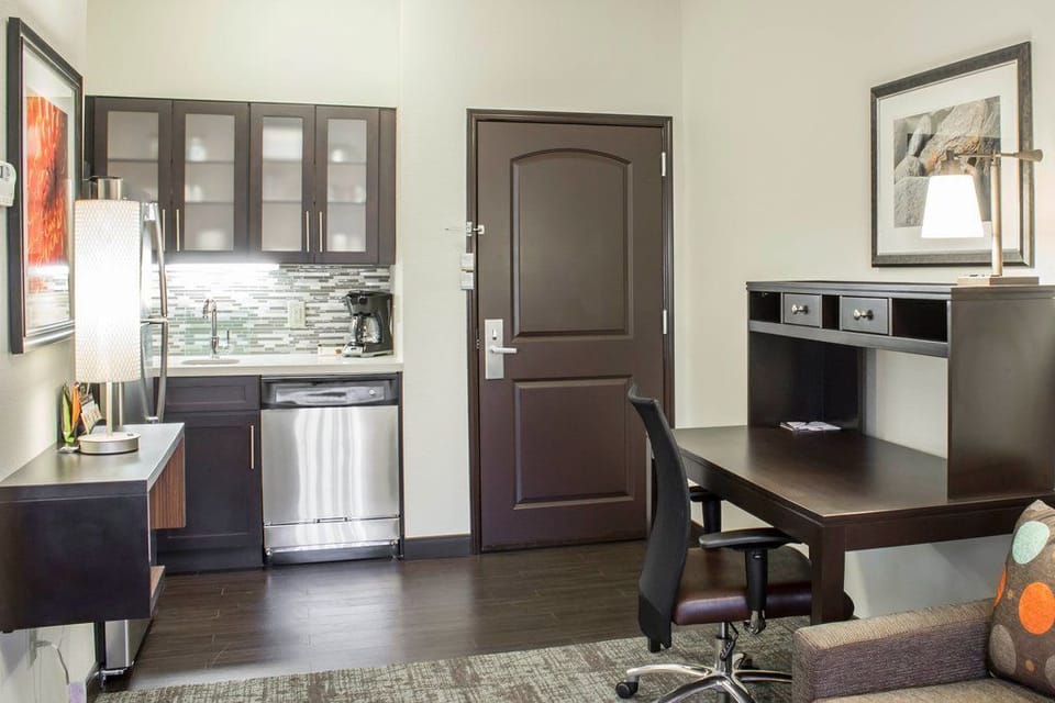 A cozy work area is complemented by tasteful decor and natural light, creating an inviting space to catch up on work or relax.