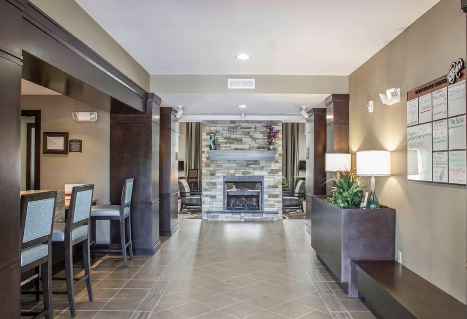 Gather in the welcoming lobby featuring a cozy stone fireplace and comfortable seating for guests to relax.