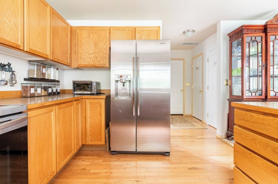 Kitchen has refrigerator with two more refrigerators in the garage