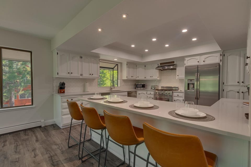 - Bright kitchen with sleek white cabinetry  
- Large island seating and quartz counters  
- Perfect for cooking Tahoe vacation meals